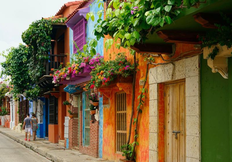 A colorful street with flowers on the balconies